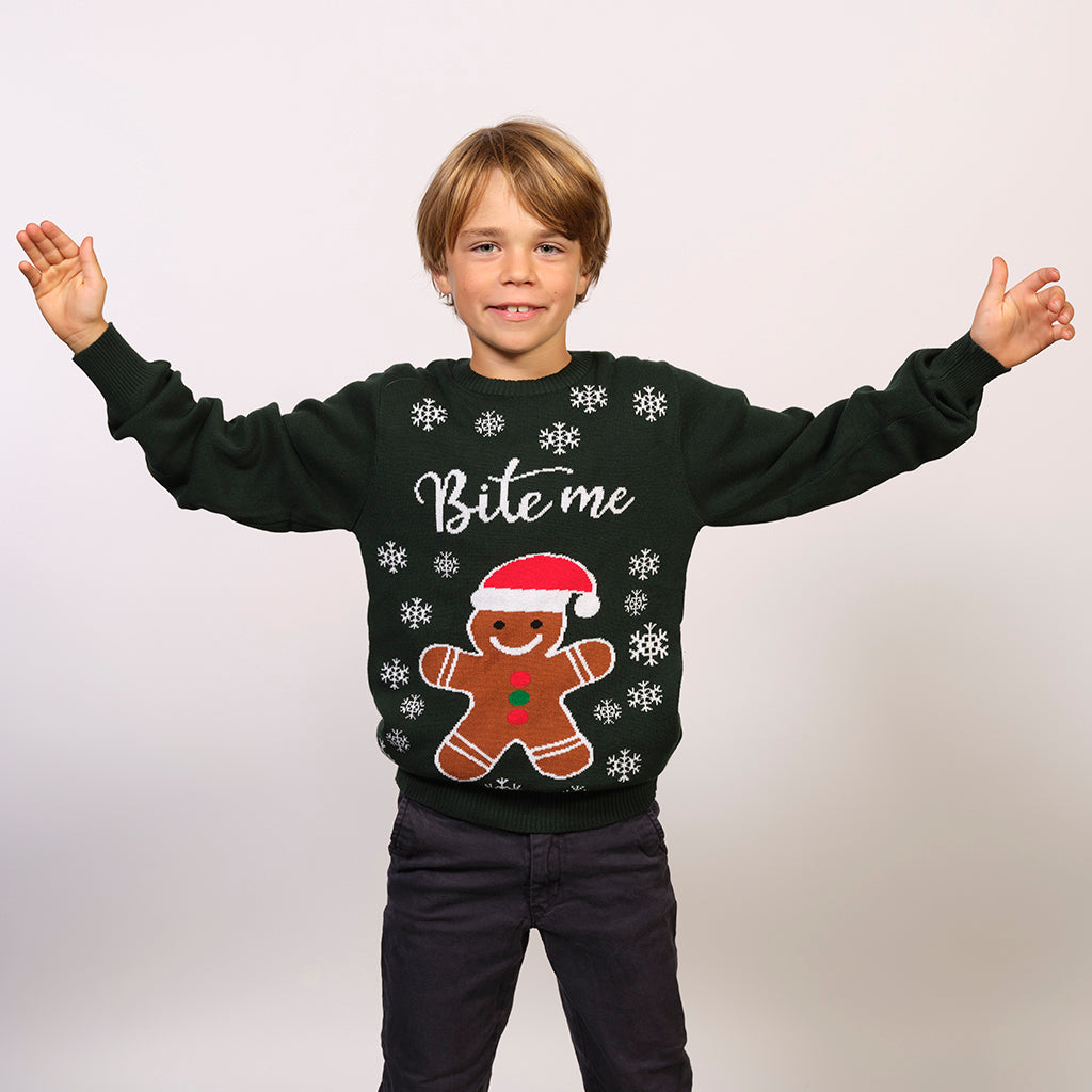 En dreng med en grøn julesweater med en kagemand og citater "Bite me".