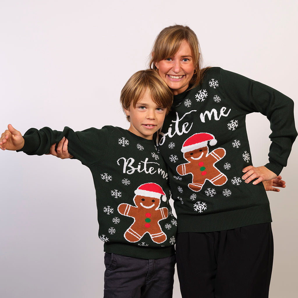 En dame og en dreng holder om hinanden, og begge har grønne julesweatre på.