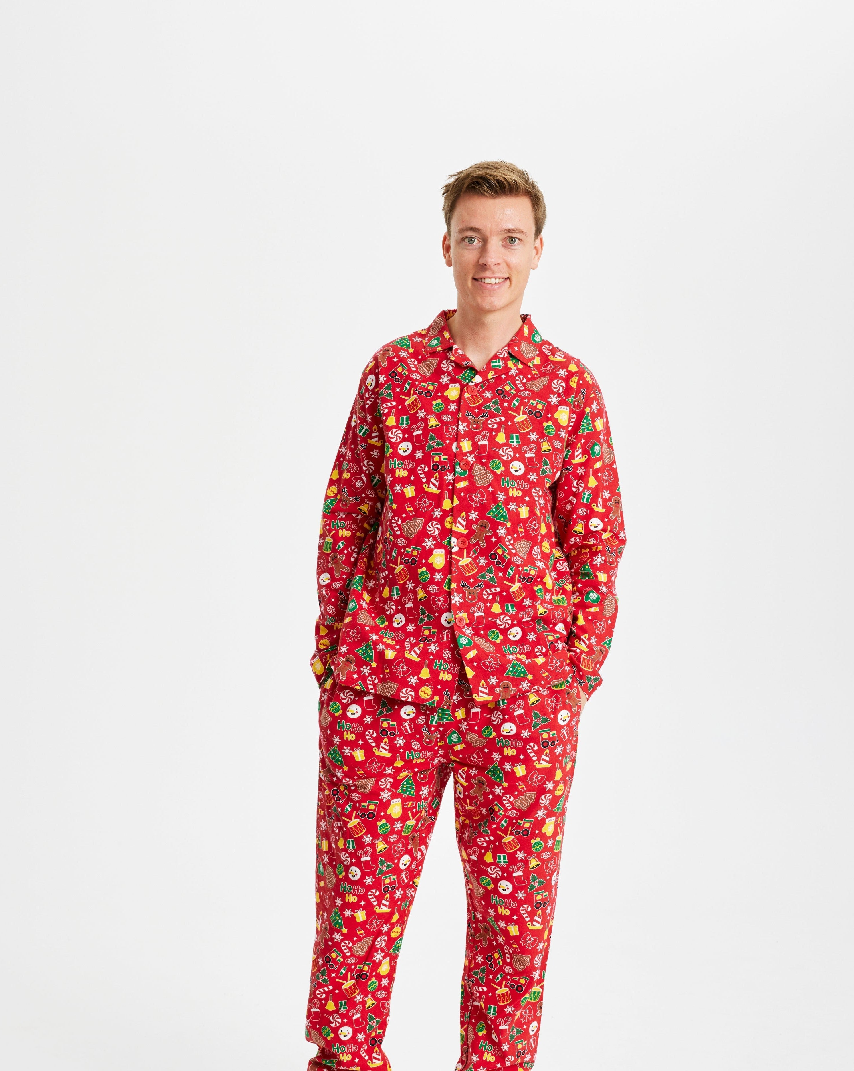 En mand iført en rød julepyjamas med forskelligt julepynt på.