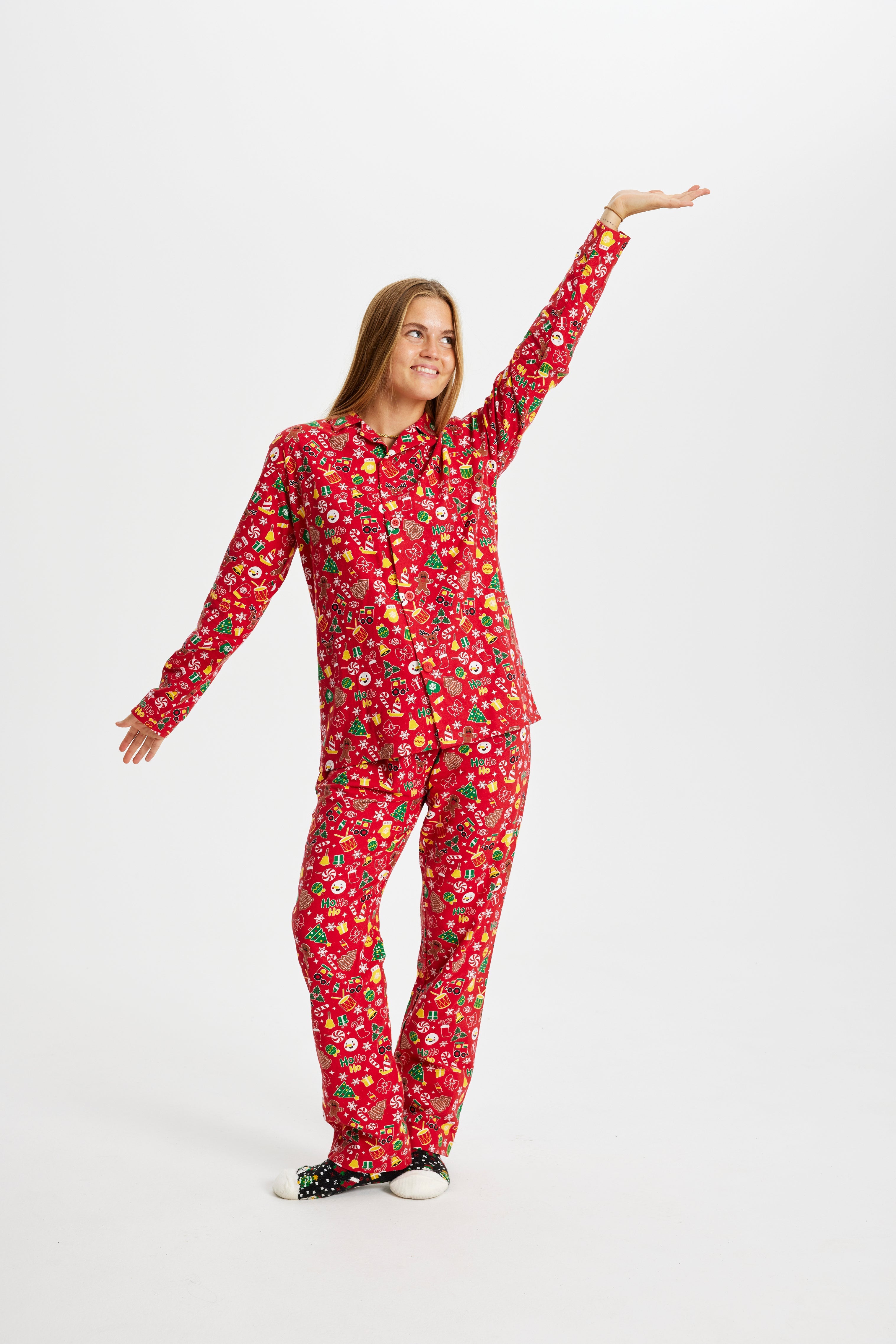 En poserende dame iført en rød julepyjamas med mønster på.