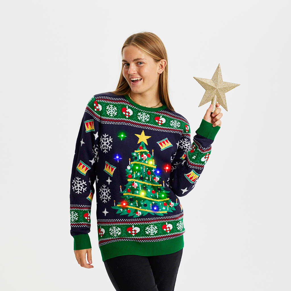 En kvinde med en julestjerne i hånden er iklædt en julesweater med lys.