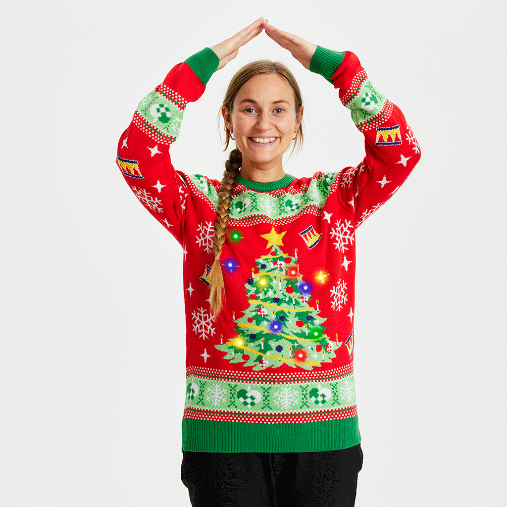 En kvinde iført en rød julesweater med lys på.