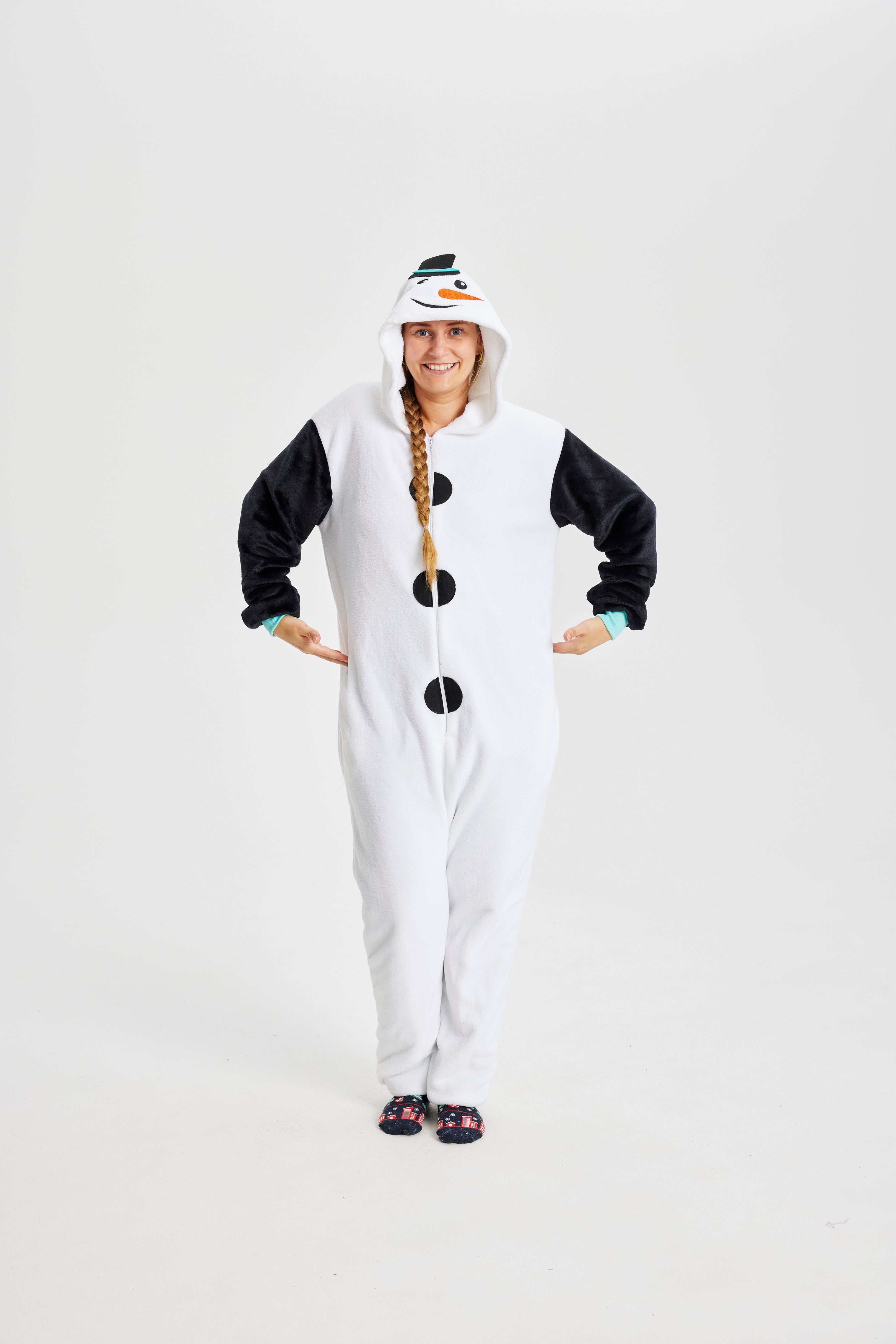 En kvinde iført en hvis jumpsuit med juletema.