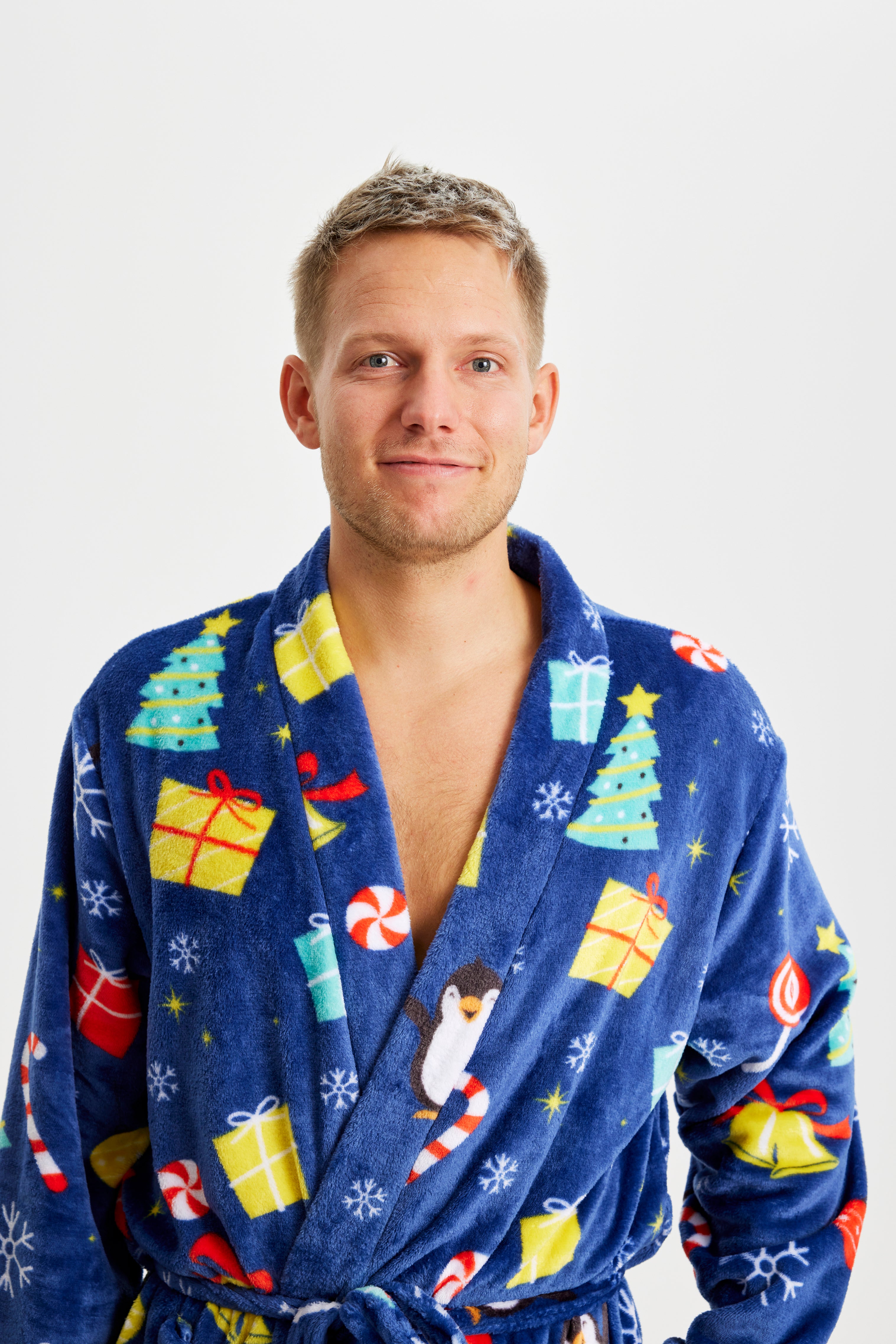 En smilende mand iført en blå julebadekåbe.