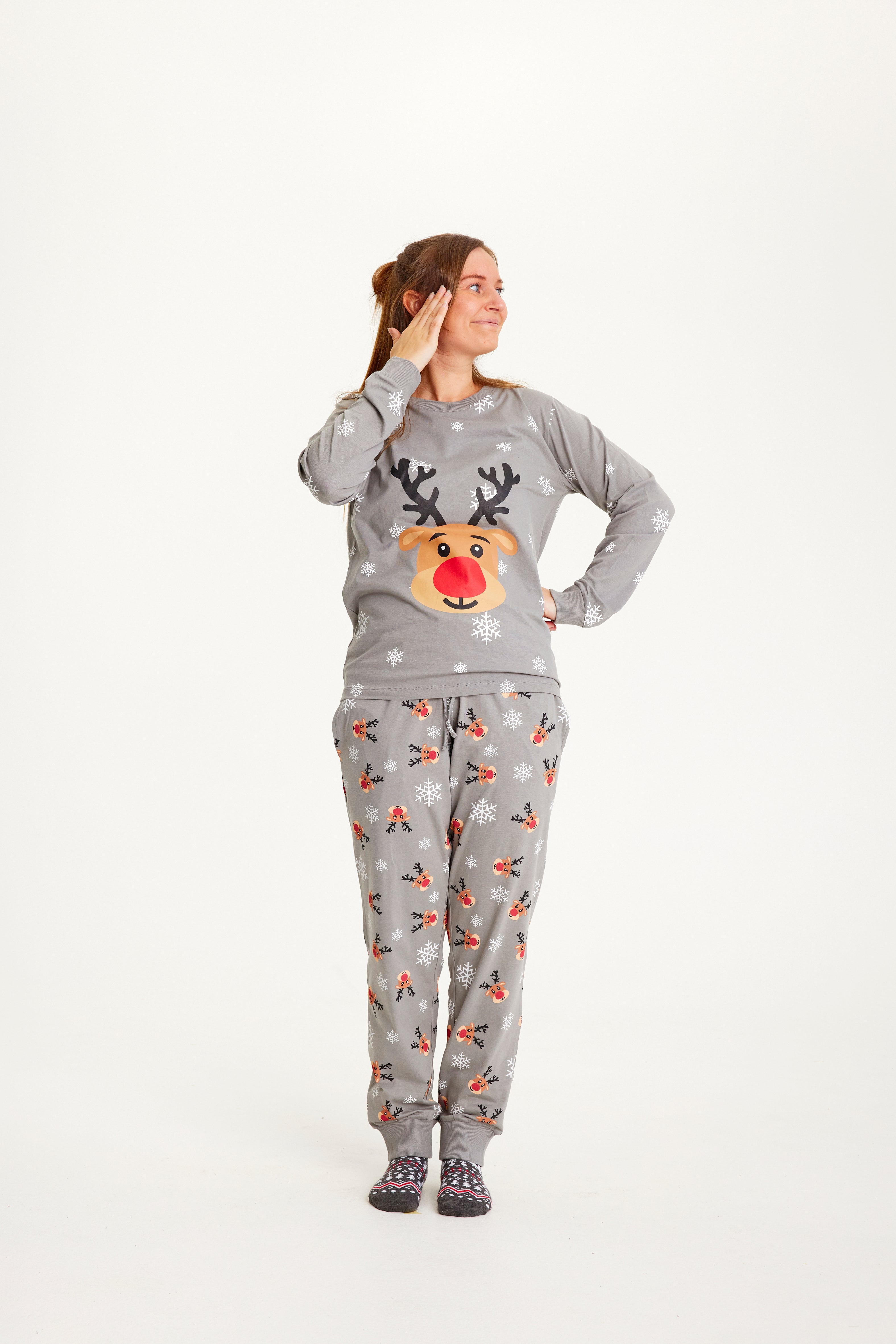 En poserende dame iført grå julepyjamas.