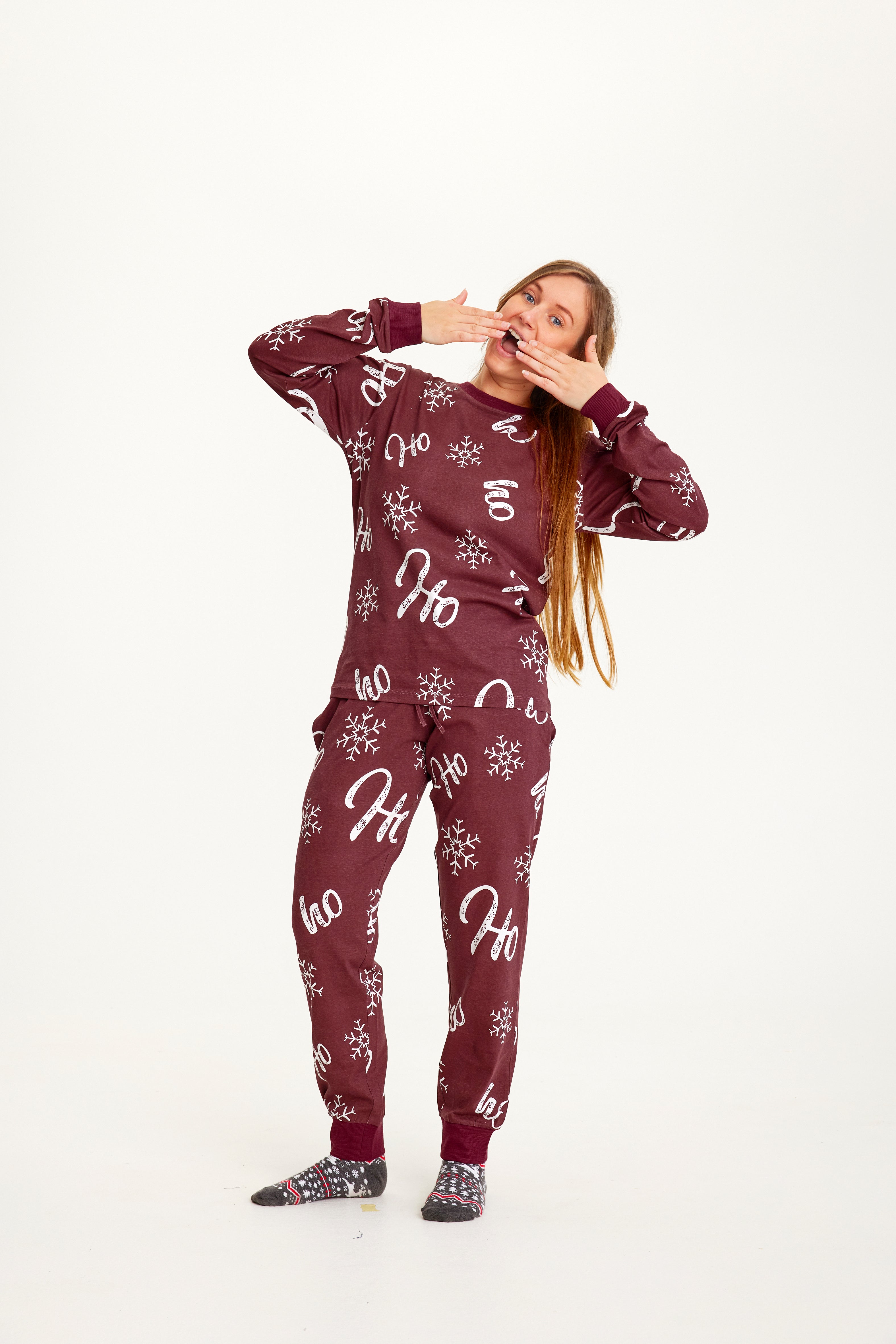 En kvinde i et mørkerødt pyjamassæt.