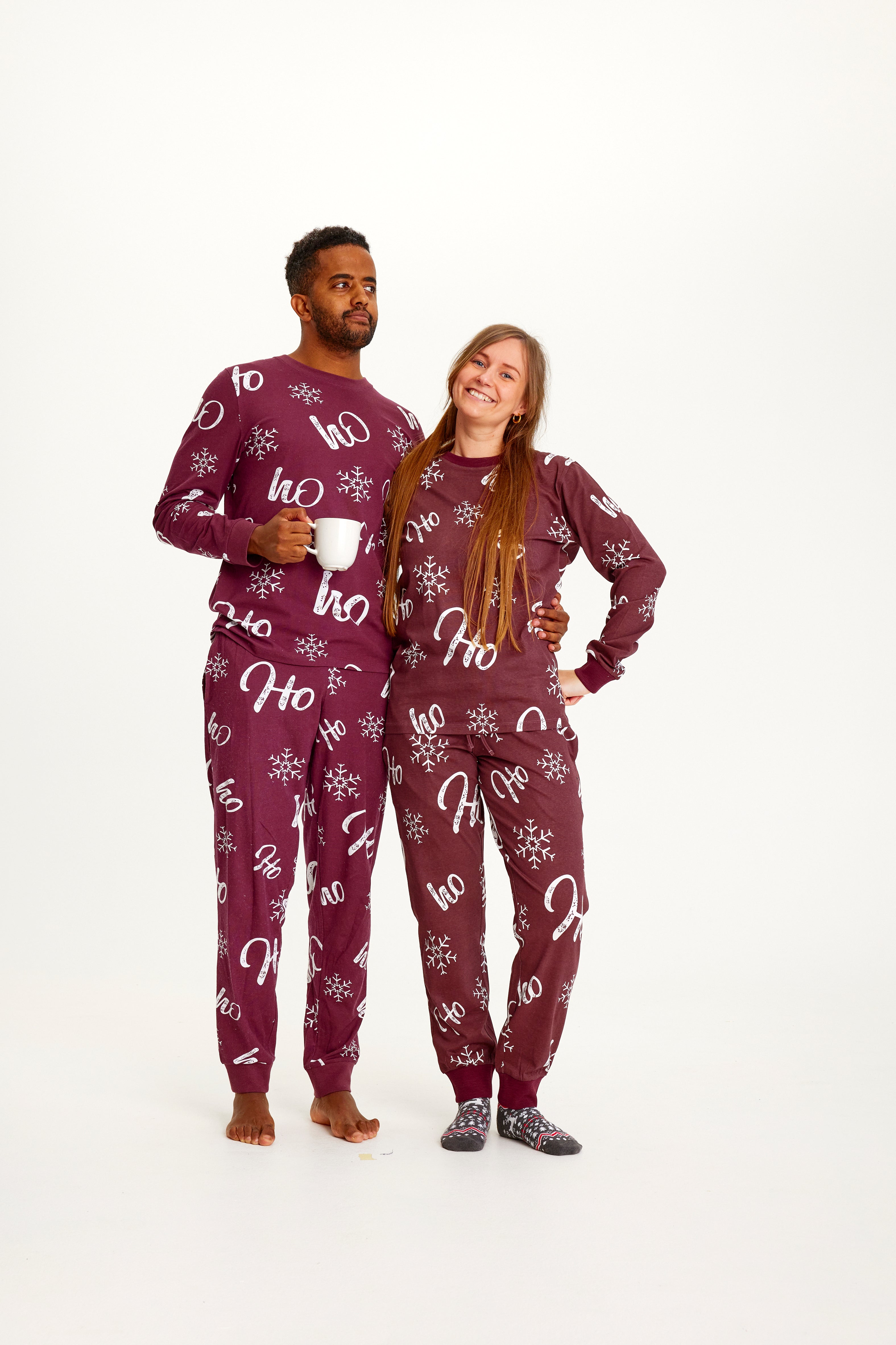 En mand og en kvinde begge iført røde julepyjamas.