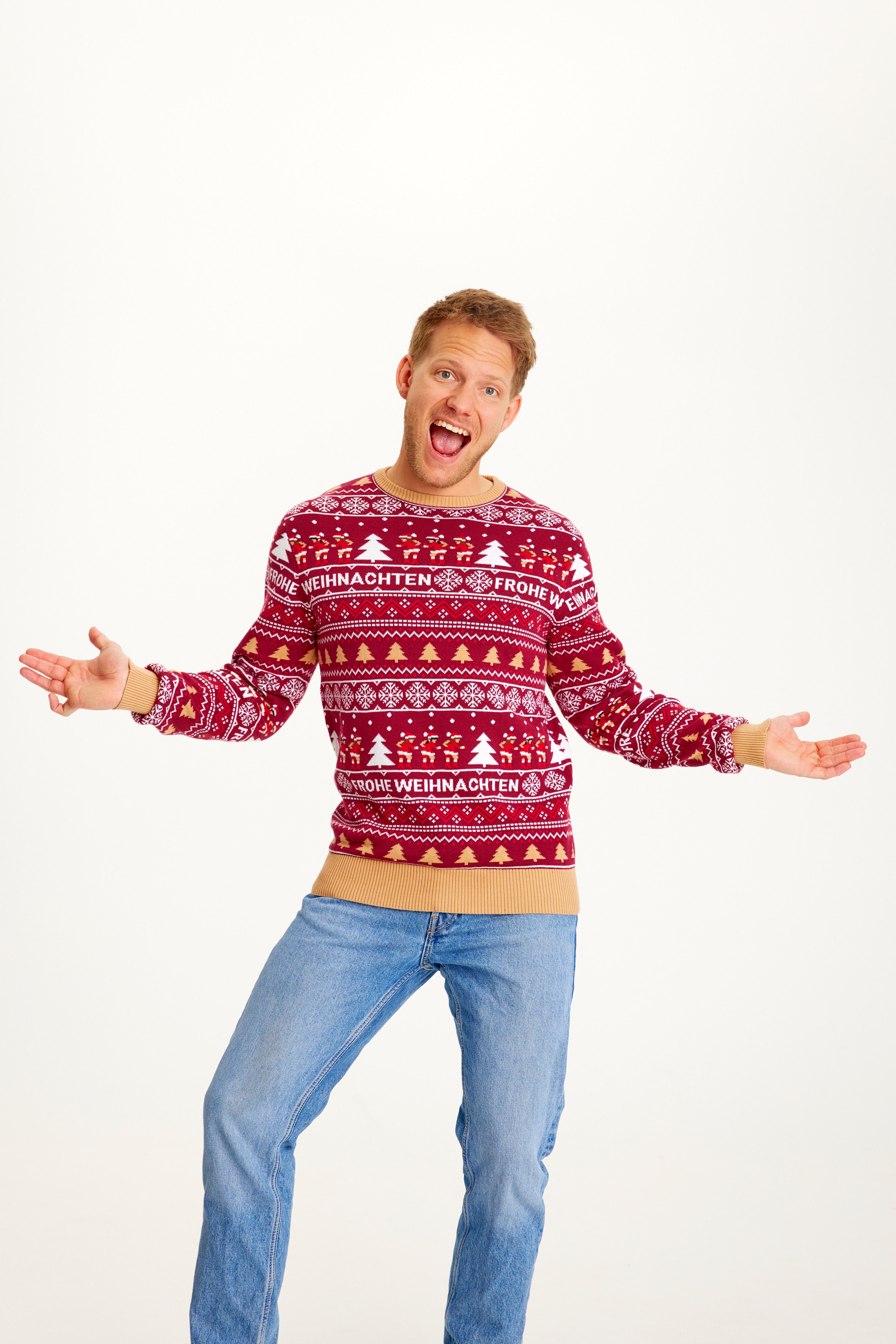 En glad man iført en rød julesweater med julemønster.