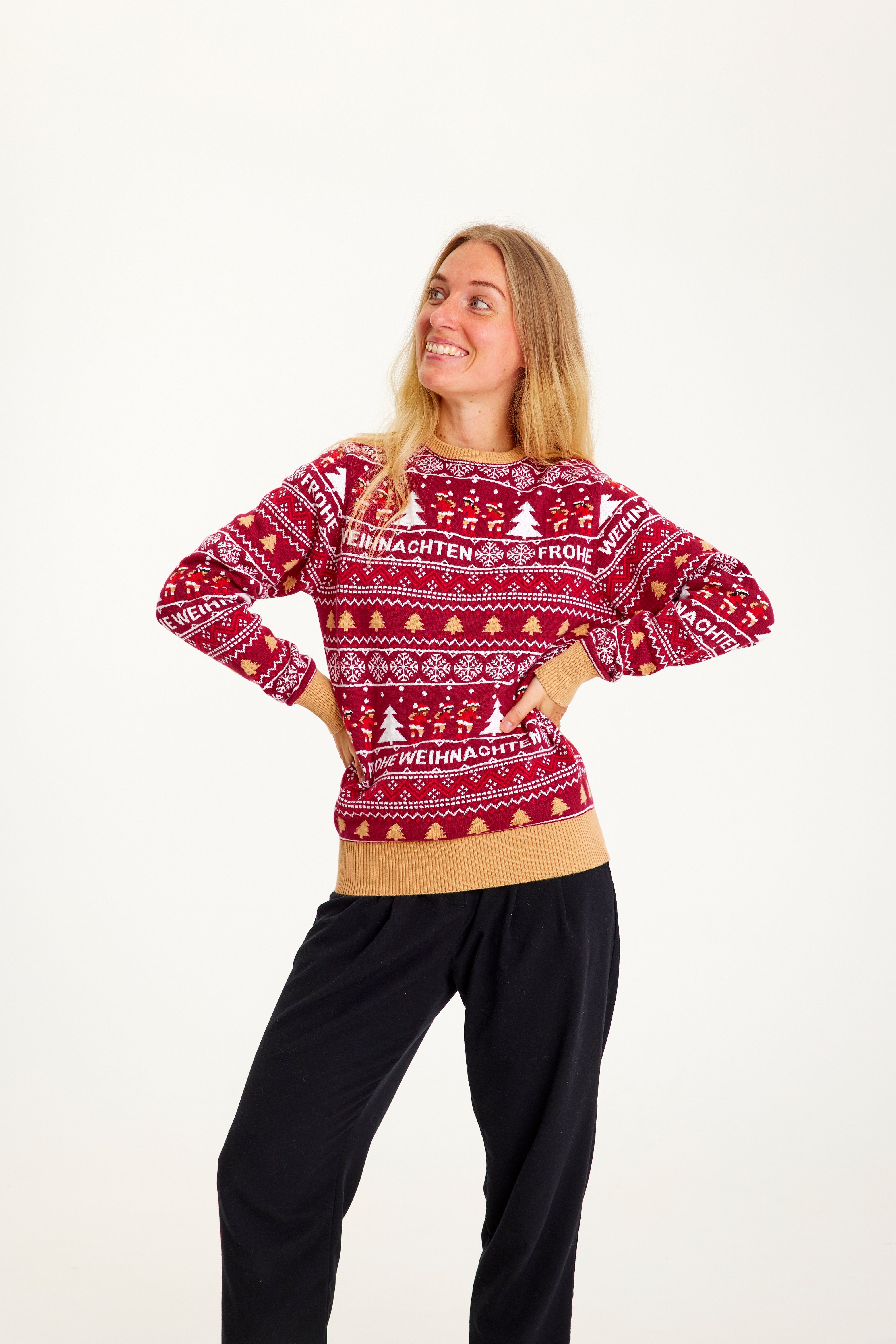 En smilende dame, der kigger til siden iført en rød julesweater.