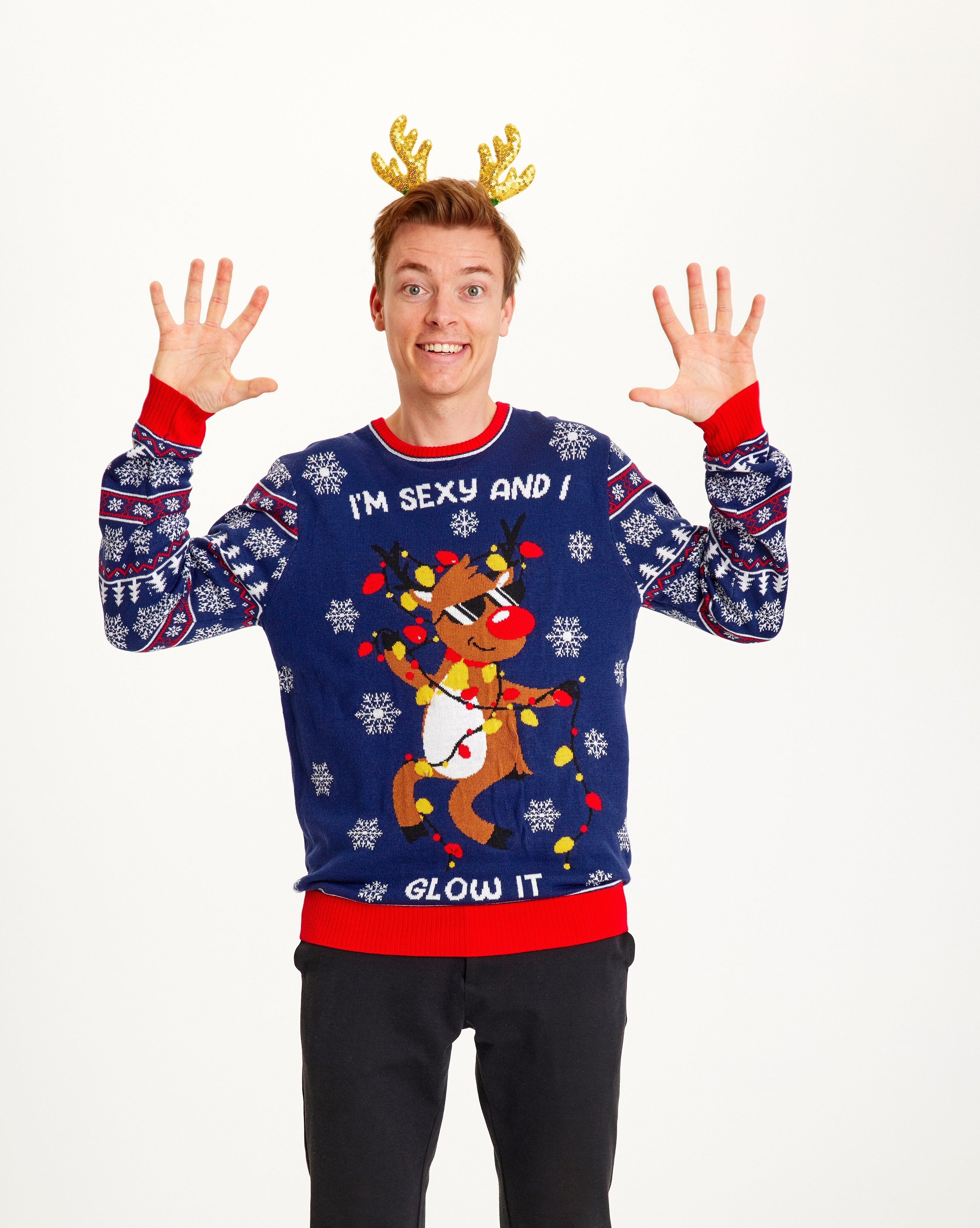 En mand iført en julesweater med citatet "I'm sexy and I glow it".'